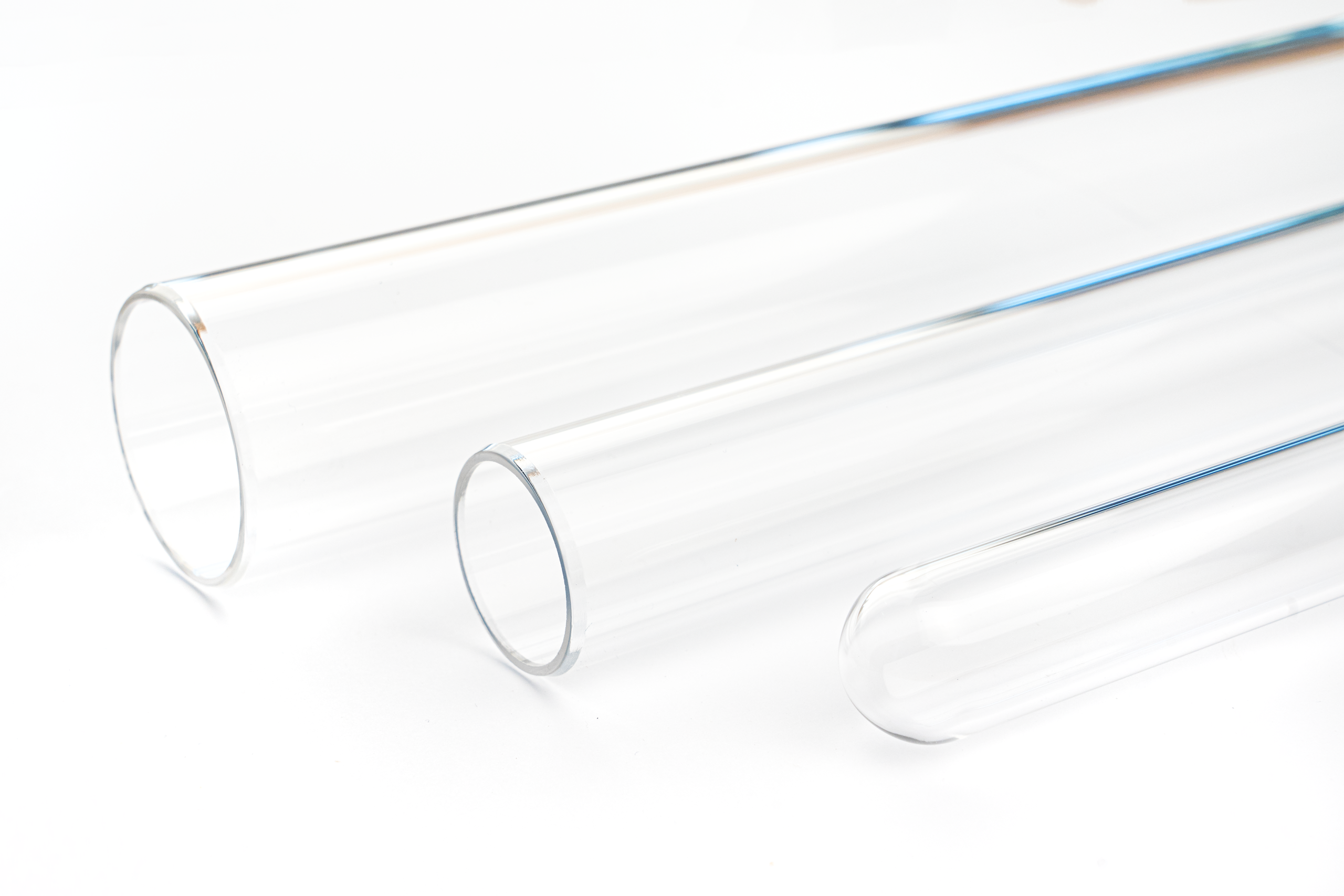 Three quartz glass tubes with different diameters used as UV protection sleeves in water treatment and pharmaceutical applications.